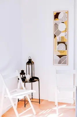 a white chair in a room with a table and a picture at The Nest Apartment - Sea View - Faro in Faro