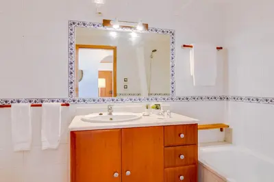 a bathroom with a sink and a tub and a mirror at The Nest Apartment - Sea View - Faro in Faro