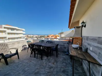 a patio with a table and chairs on a roof at Sea view Penthouse 10 min walking Albufeira old town and Beach Pescadores in Albufeira