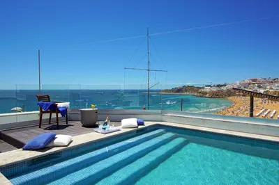 a swimming pool with a view of the ocean at Casa da Bandeira -Perfect Location-Beach front- Rooftop Pool by DreamvillasAlbufeira in Albufeira