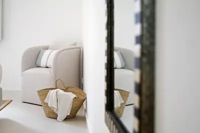 a living room with a couch and a basket in front of a mirror at Casa da Bandeira -Perfect Location-Beach front- Rooftop Pool by DreamvillasAlbufeira in Albufeira