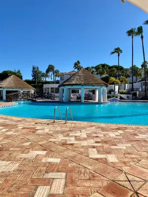 a large swimming pool in a resort with palm trees at Beautiful apartment for rent in Quinta do Lago with excellent resort facilities close to lake and beach. in Quinta do Lago
