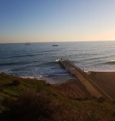 a pier in the ocean with two ships in the water at 