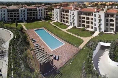 a white living room with a couch and a table at Gardens Pool by FHR Golf, piscina e parking in Quarteira