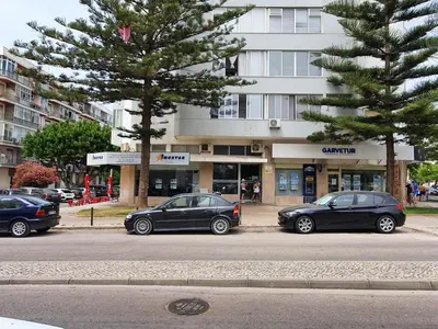 two cars parked in a parking lot in front of a building at Vista Praia 16- Wifi, Remodelado, 80mt Praia in Quarteira