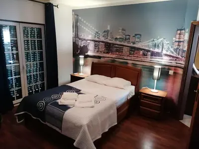 a bedroom with a large bed with two lamps on tables at Minha casa in Faro