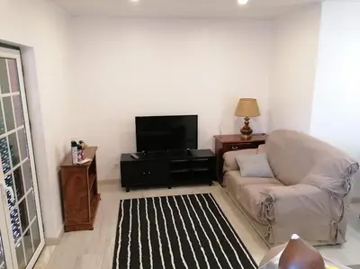 a living room with a couch and a flat screen tv at Minha casa in Faro