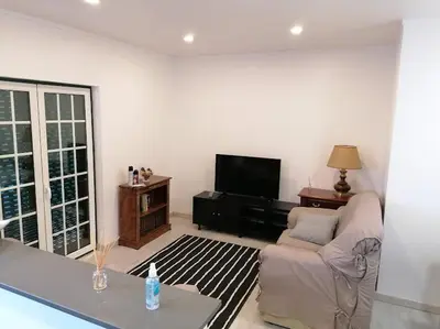 a living room with a couch and a tv at Minha casa in Faro