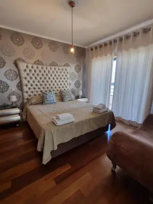 a bedroom with a large bed and a chair at Luxury city Villa Olivia 10 - 15 min to the Beach Oura, private swimming pool in Albufeira