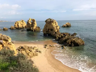 a beach with some rocks in the water at Appartement Sao Rafael praia Algarve portugal in Albufeira