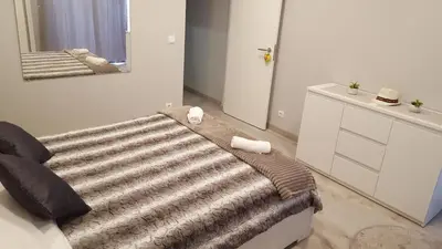 a bedroom with a couch with a striped blanket at Vila Magna Albufeira in Albufeira