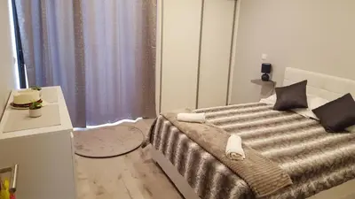 a bedroom with a bed and a table and a window at Vila Magna Albufeira in Albufeira