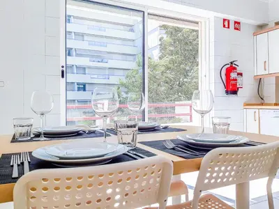 a dining room with a table and chairs and a window at Por do Sol Dourado T2 HsR Vilamarina in Vilamoura