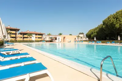 a swimming pool with blue lounge chairs in a resort at Apartamento Monte Laguna in Vilamoura