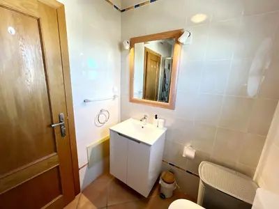 a bathroom with a sink and a mirror and a toilet at Vila Falesia Penthouse in Albufeira