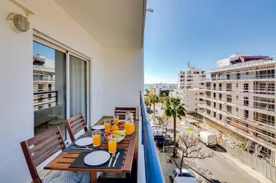 a table on a balcony with a view of a city at Colina Sol T2 Quarteira Beach in Quarteira