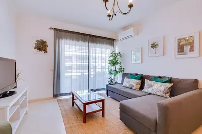 a living room with a couch and a tv at Colina Sol T2 Quarteira Beach in Quarteira