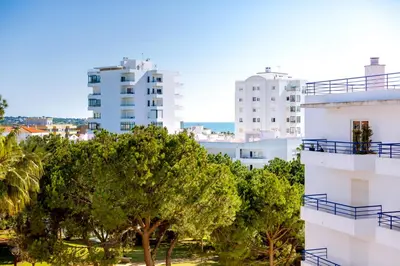 a view of a city with tall buildings and a tree at Colina Sol T2 Quarteira Beach in Quarteira