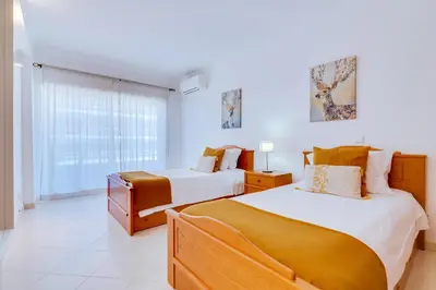 a bedroom with two beds and a window at Colina Sol T2 Quarteira Beach in Quarteira