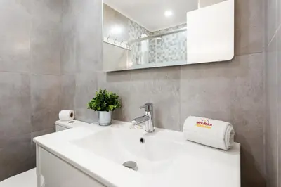 a bathroom with a white sink and a mirror at Elma By Albufeira Rental in Albufeira