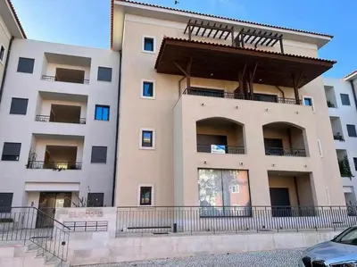 a large building with a balcony in front of it at Gardens Side By FHR piscina, parking in Quarteira