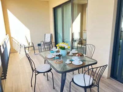 a dining room with a table and chairs at Gardens Side By FHR piscina, parking in Quarteira