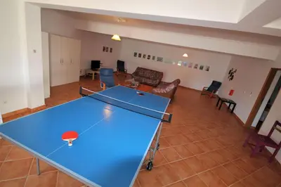 a ping pong table in the middle of a living room at Villa Olive in Loulé