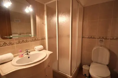 a bathroom with a sink and a toilet and a mirror at Villa Olive in Loulé