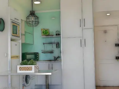 a kitchen with white cabinets and a table at Mira Praia, Sunny and Sea in Quarteira