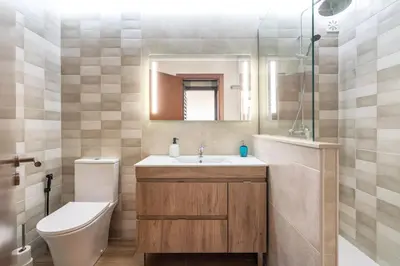 a bathroom with a sink and a toilet and a mirror at Holiday house in elite residential area of Faro in Faro