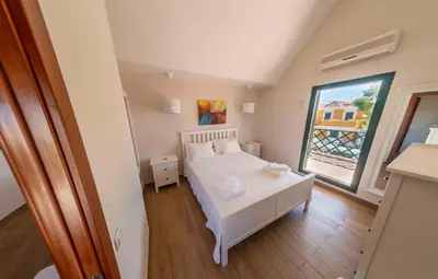 a bedroom with a white bed and a large window at Holiday house in elite residential area of Faro in Faro