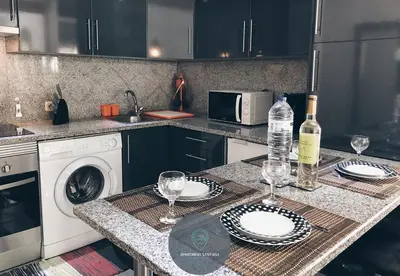 a kitchen with a table with wine bottles and glasses at Apartment Sant'Ana Old Town Albufeira - Bay View in Albufeira