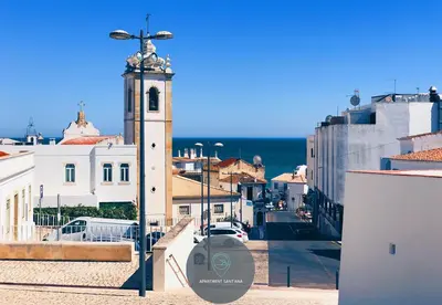 a clock tower with a statue on top of a city at Apartment Sant'Ana Old Town Albufeira - Bay View in Albufeira