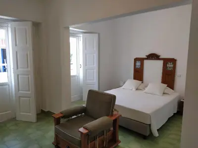 a bedroom with a bed and a chair at Urban Apartment in Faro