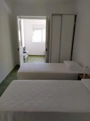 two beds in a room with a door open at Urban Apartment in Faro