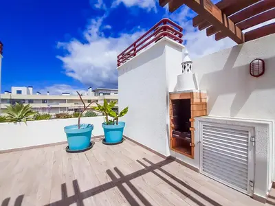 a patio with two blue pots on a wooden deck at Penthouse Triplex L25 T2 by HsR Vilamarina in Vilamoura