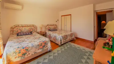 a bedroom with two beds and a table with a lamp at Penthouse Triplex L25 T2 by HsR Vilamarina in Vilamoura