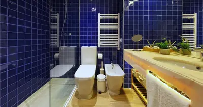 a blue tiled bathroom with two toilets and a sink at Victory Village 18E in Quinta do Lago
