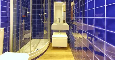 a blue tiled bathroom with a toilet and a sink at Victory Village 18E in Quinta do Lago