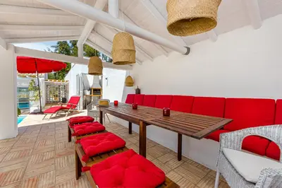a living room with a red couch and chairs at Villa AL Fresco in Guia