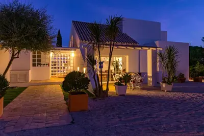 a house with palm trees in front of it at night at Villa AL Fresco in Guia