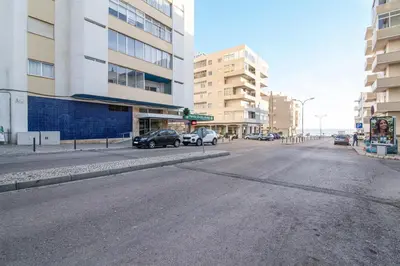 an empty street in a city with cars parked at Modern Apartment by the Sea in Quarteira