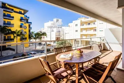a balcony with a table and chairs and a view of a city at Varandas Golden Beach in Quarteira