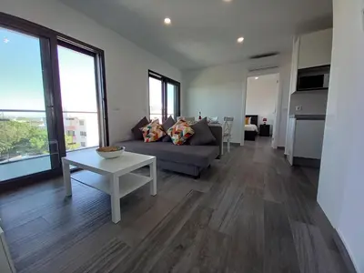 a living room with a couch and a table at Alto do Forte Novo- Ar- Condicionado, Wifi, Vista Mar in Quarteira