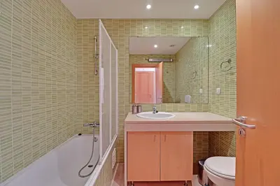a bathroom with a tub and a sink and a toilet at Albufeira Modern 1 with pool by Homing in Albufeira
