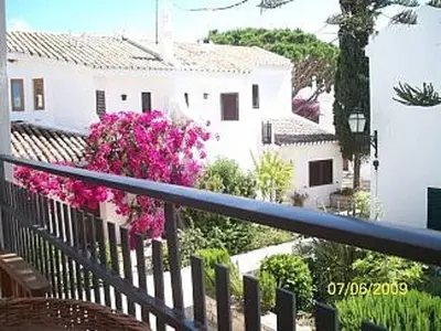 a balcony with pink flowers and a white building at Casa Vale Do Lobo 32 Charming 2 Bedroom Townhouse Close To Beach in Vale do Lobo