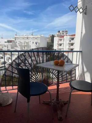 a table and chairs on a balcony with a view of a city at Apartament near the ocean in Albufeira