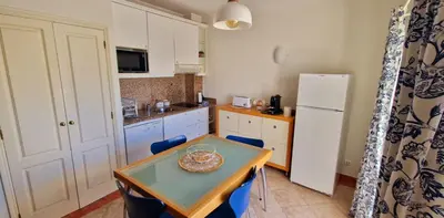 a small kitchen with a table and a refrigerator at Praia Oura Sunset in Albufeira