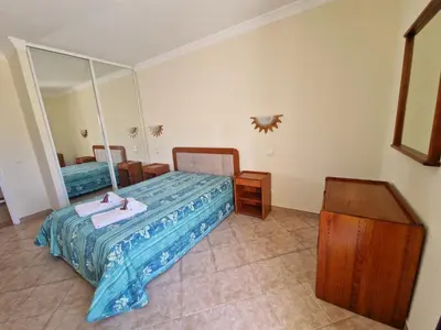 a bedroom with a bed and a large mirror at Praia Oura Sunset in Albufeira
