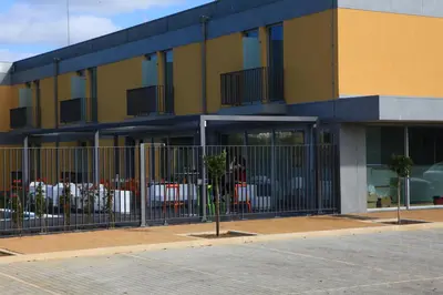 a restaurant with tables and chairs next to a pool at Hotel 3K Faro Aeroporto in Faro